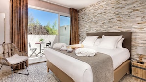 A hotel room with a large bed, a small table, a chair, and a view of the outdoors. - Vila de la Mar & Spa (Saintes-Maries-de-la-Mer)
