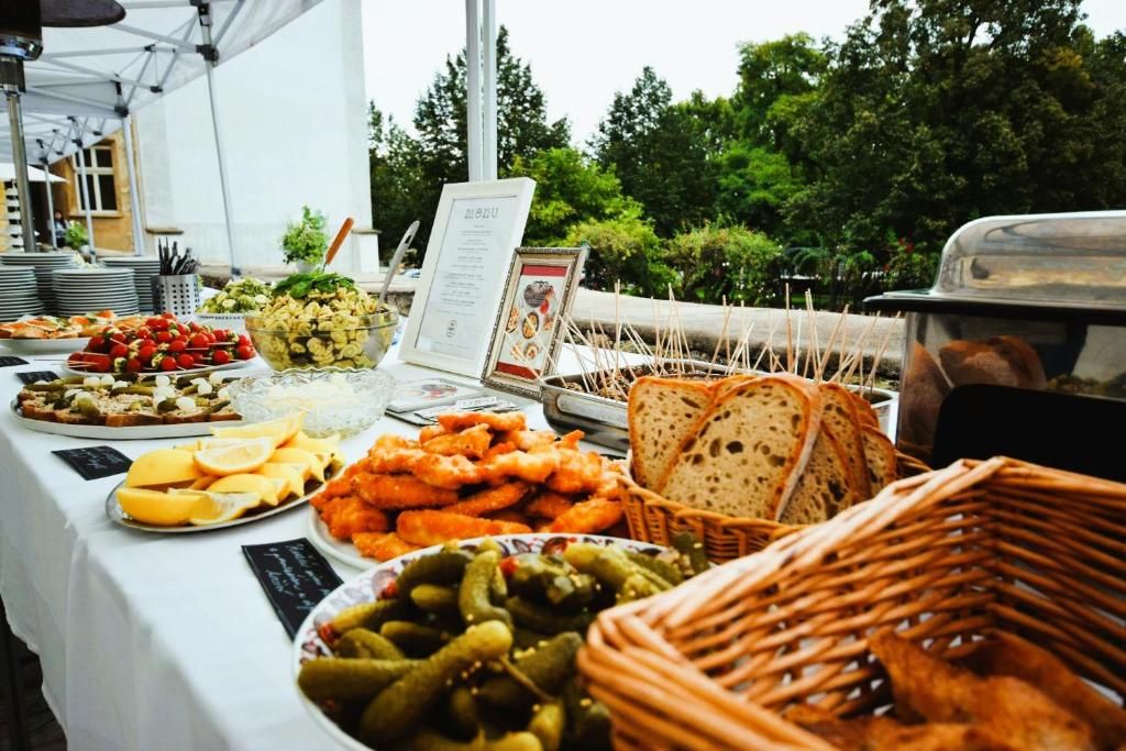 A buffet table with various food items and a menu sign.