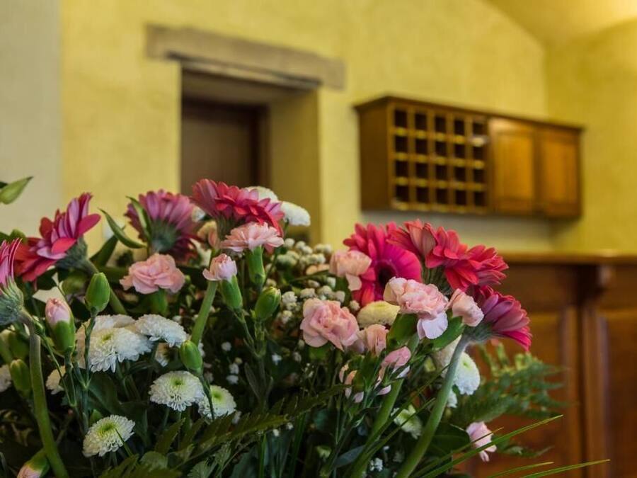 A bouquet of flowers in a room with wooden cabinets and a white door in the background.