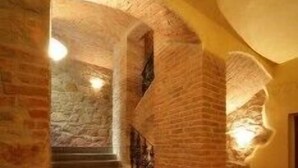 A staircase with brick walls and stone steps, leading to a higher level. - Hotel Rous (Plzen)