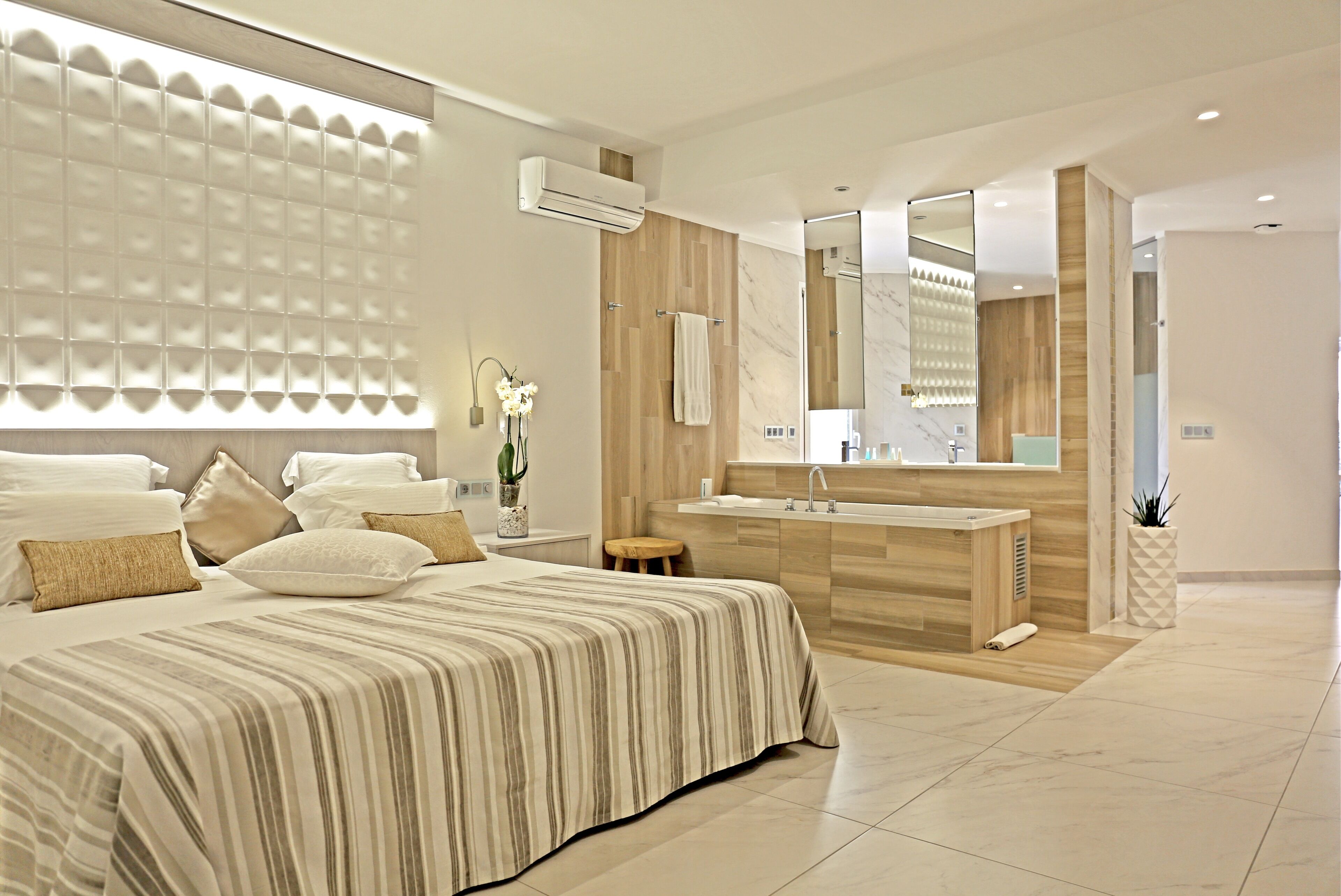 Un dormitorio moderno con una cama grande, un tocador de madera y un espejo amplio.