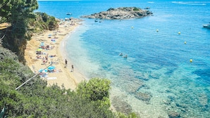 A beach with clear blue water, sandy shore, and rocky outcrops. - Hotel Vistabella (Roses)