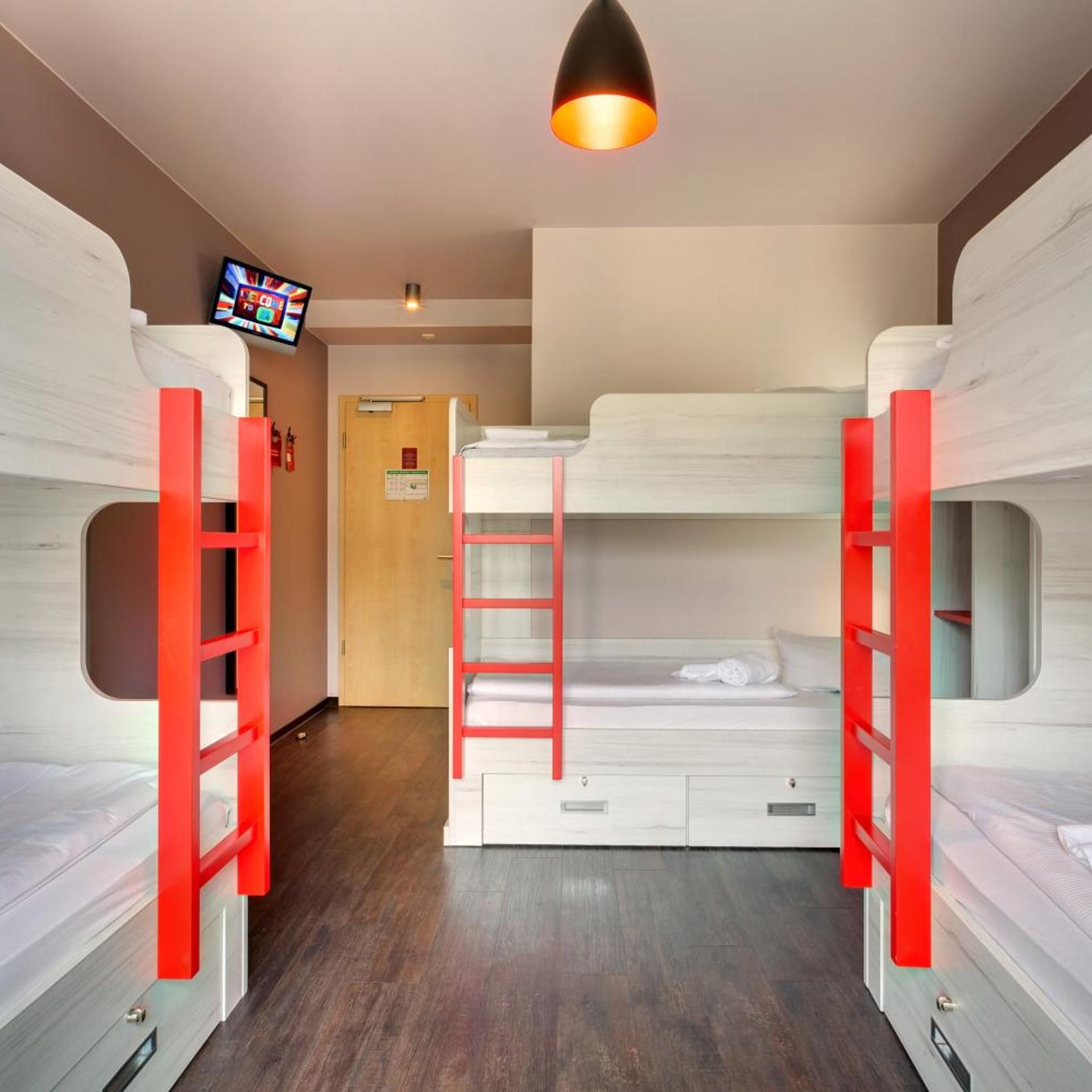 A bunk room with two bunk beds, a television, and a door with a sign.