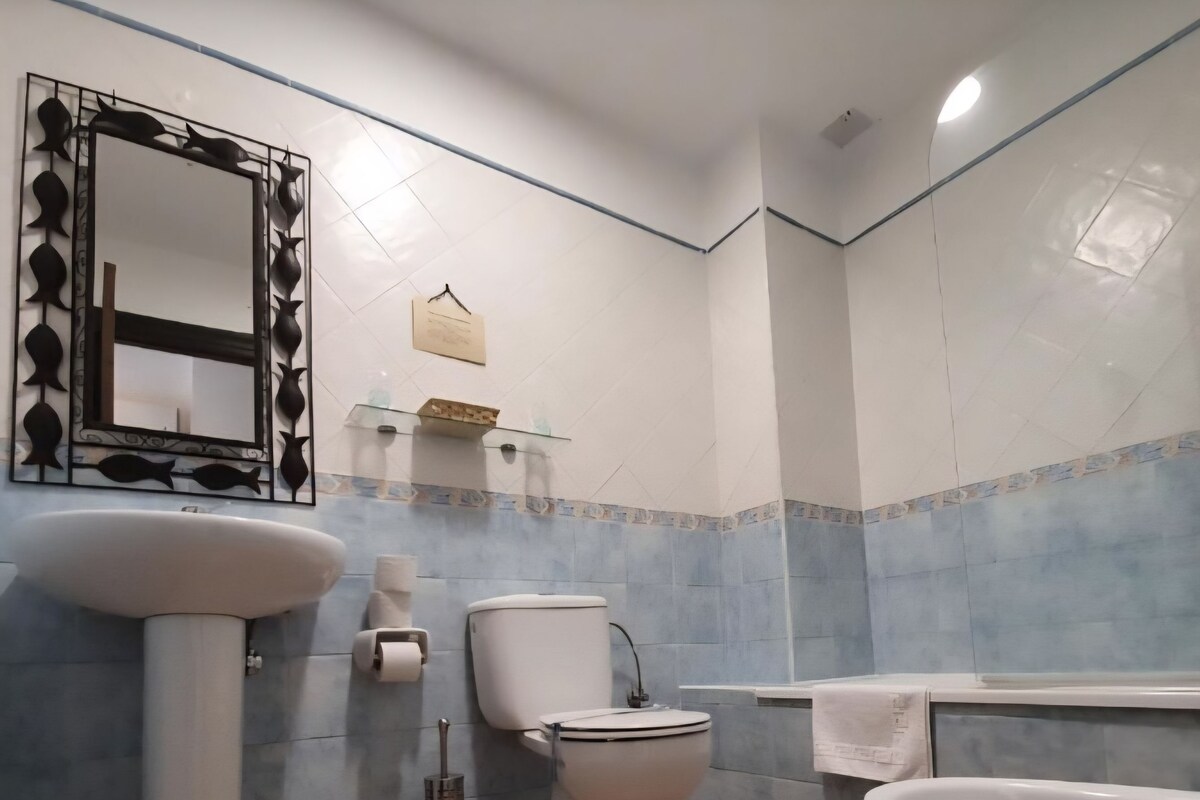 A bathroom with a toilet, sink, and bathtub.