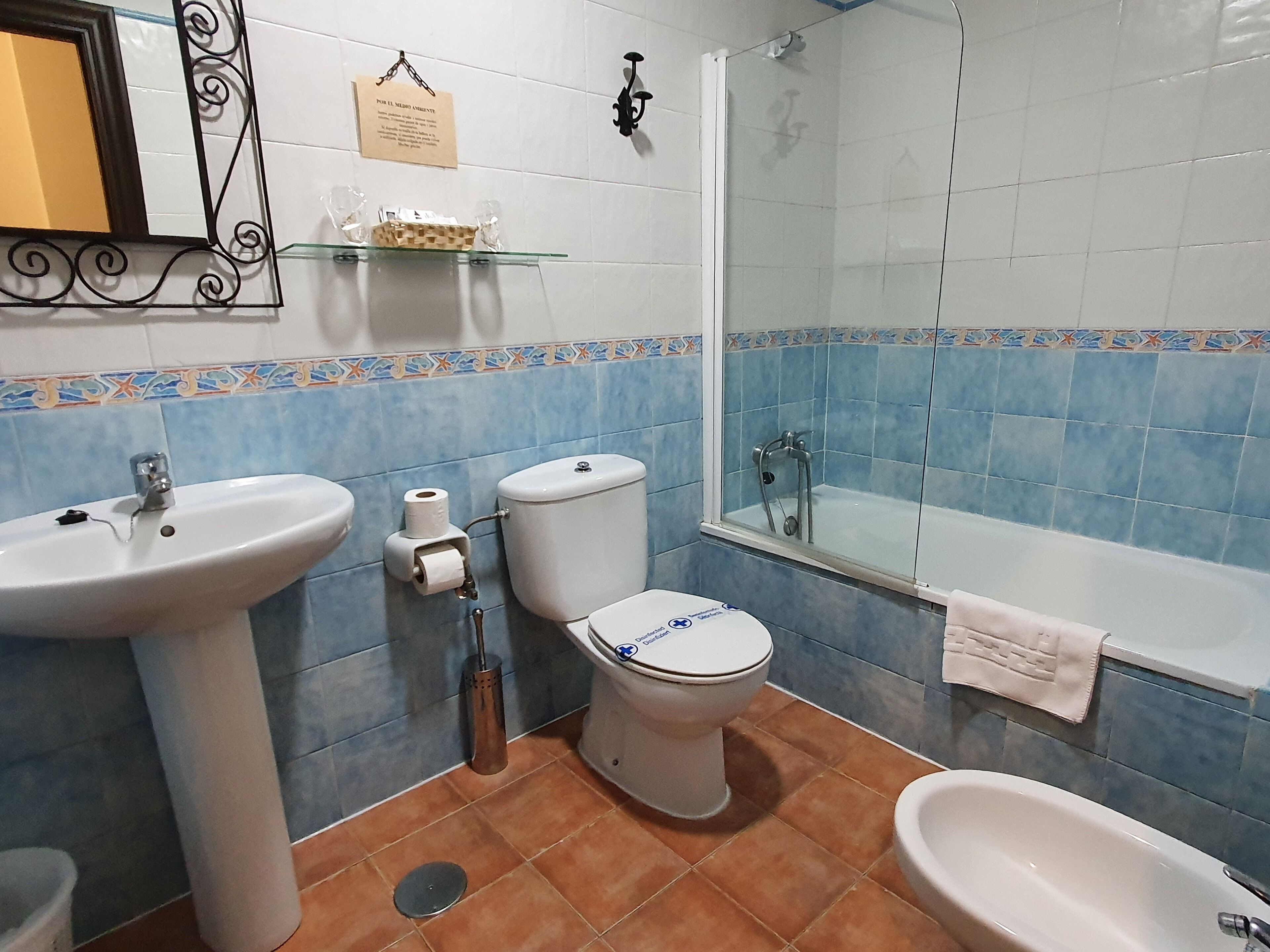 A bathroom with a sink, toilet, bidet, and bathtub.