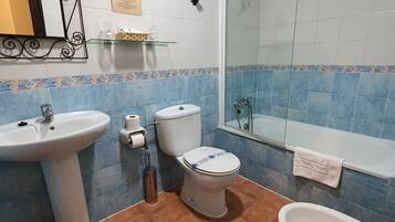 Un baño con lavamanos, inodoro, bidé y bañera.