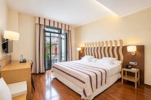 A hotel room with a bed, bedside table, lamp, and a desk with a chair. - Duran Hotel & Restaurant (Figueres)