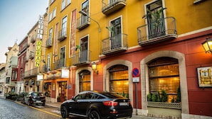 A black car parked on a cobblestone street in front of Hotel Duran. - Duran Hotel & Restaurant (Figueres)