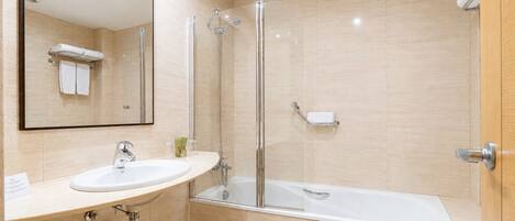 A modern bathroom with a sink, mirror, shower, and bathtub.