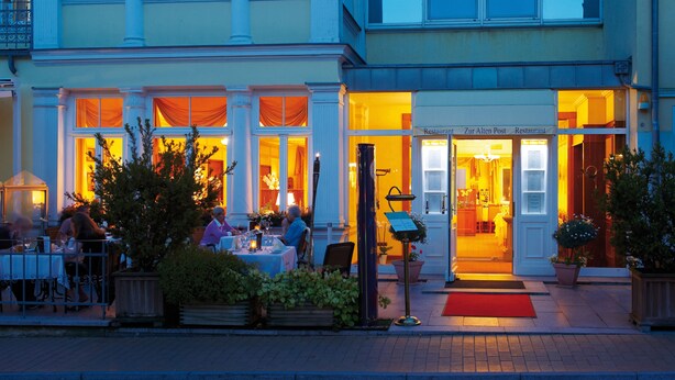 Un restaurante con terraza y una entrada alfombrada de color rojo.