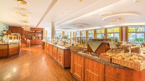 A spacious buffet area with wooden cabinets and a variety of food items displayed on the counter. - Hotel zur Post – ein Rovell Hotel (Heringsdorf)
