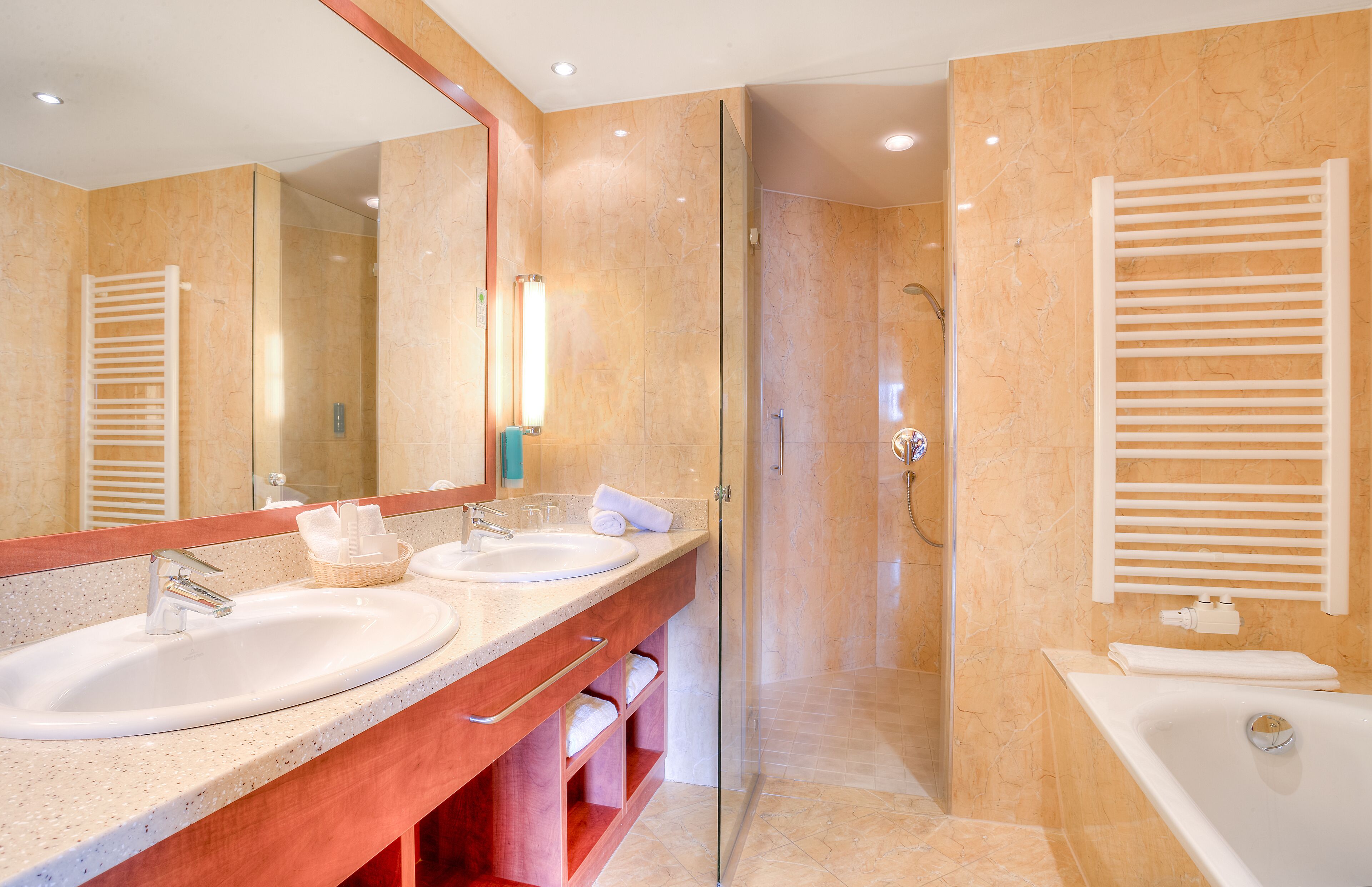 Ein modernes Badezimmer mit zwei Waschbecken, einer Duschkabine und einer separaten Badewanne.