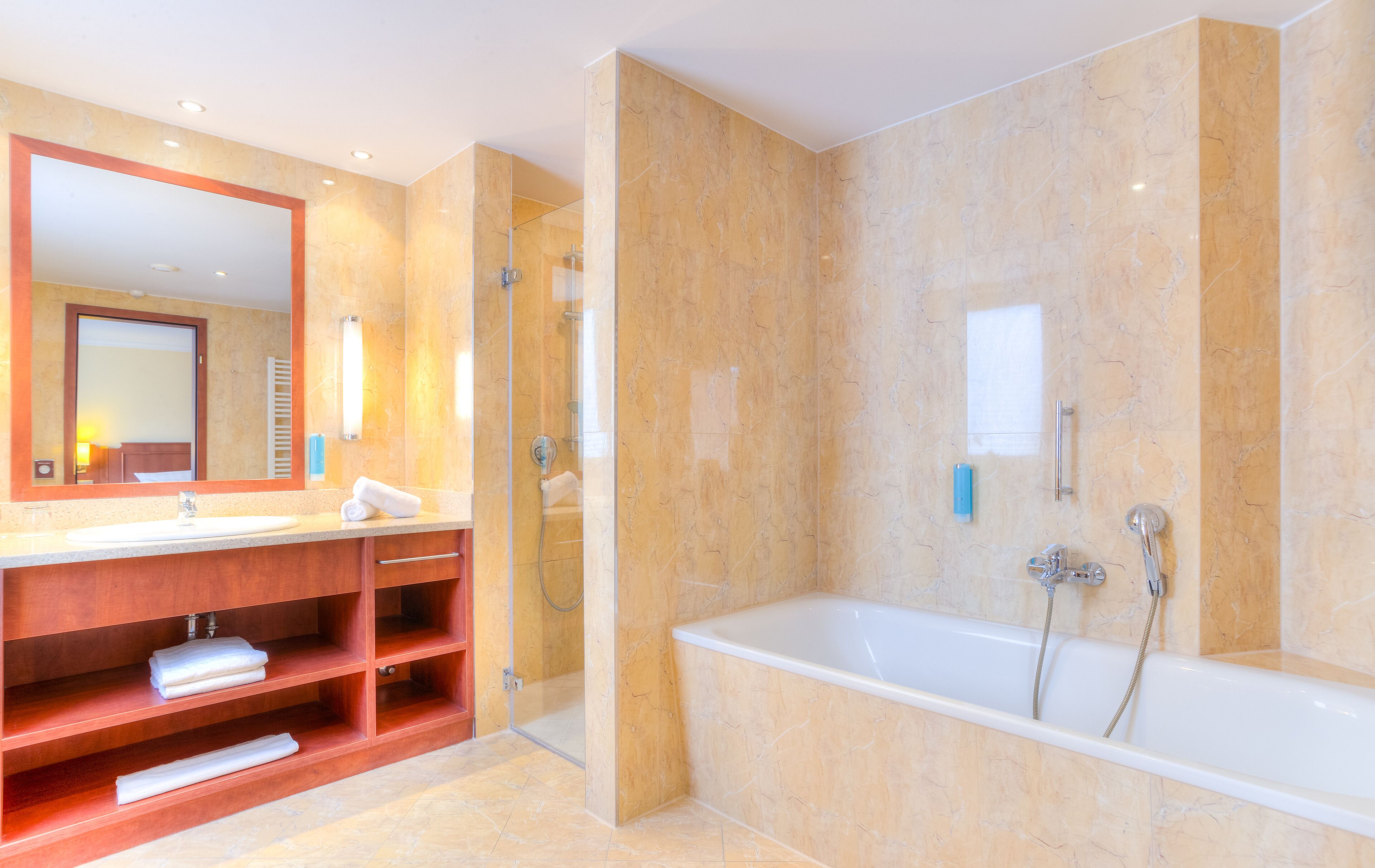 A modern bathroom with a large mirror, a vanity with shelves, a bathtub, and a shower enclosure.