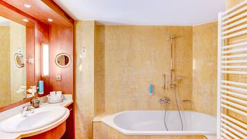 A bathroom with a sink, mirror, and bathtub.