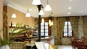 A hotel lobby with a reception desk, a bar area, and a dining area. - Hotel Imperion (Parres)