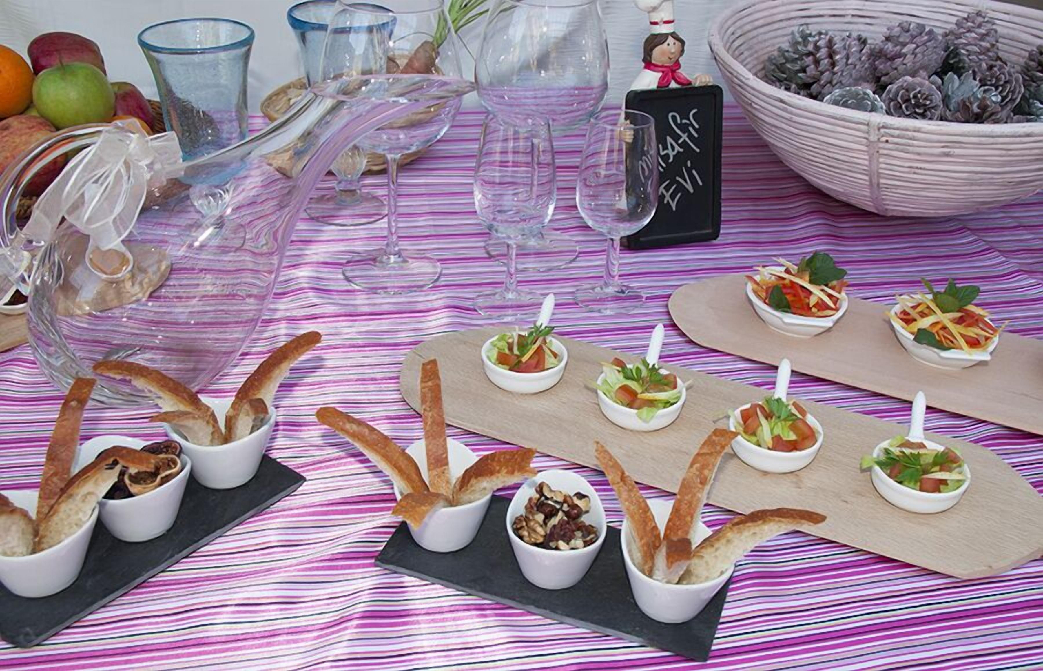 A table set with various food items, including bread, nuts, and small bowls of salad.