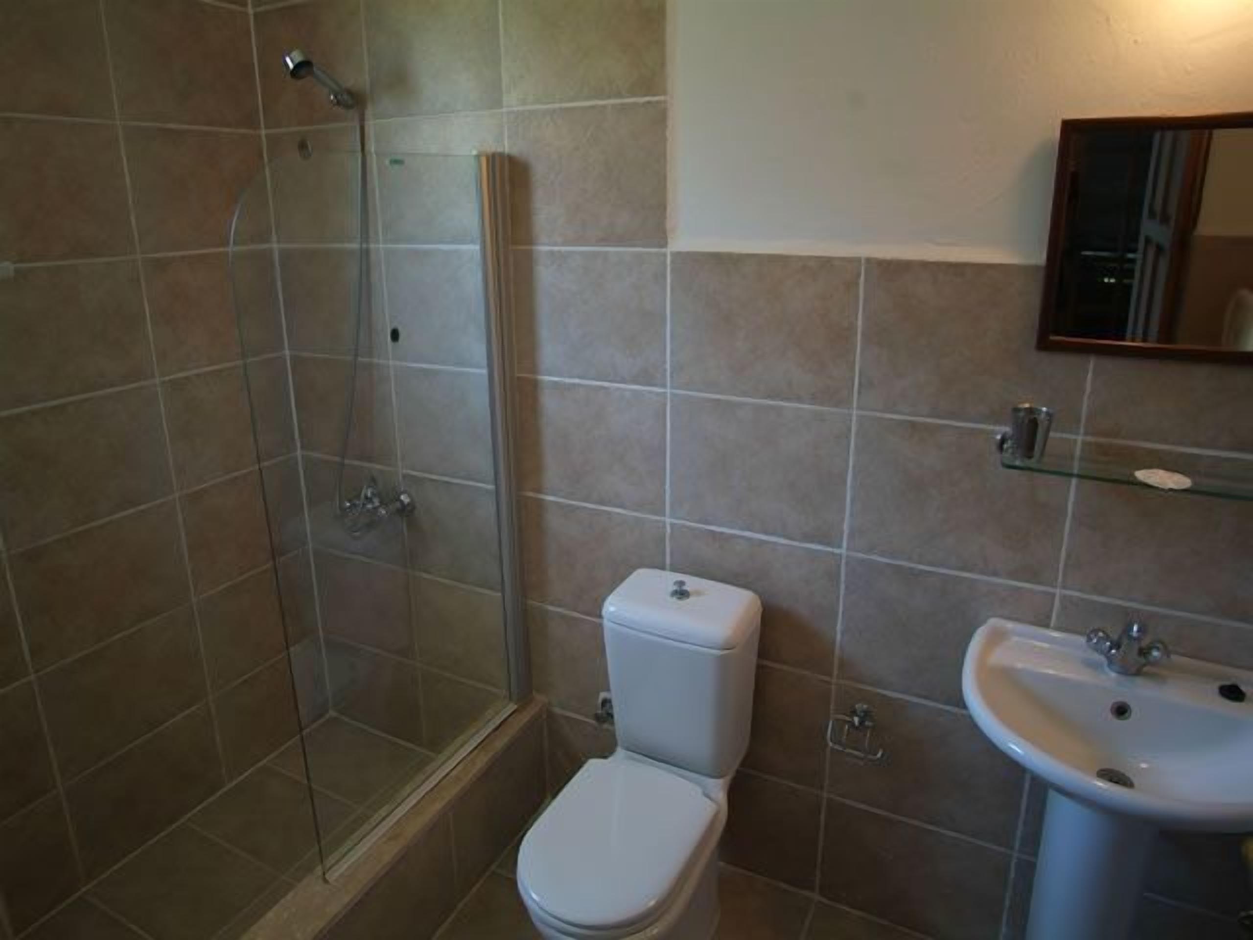 A bathroom with a shower, toilet, and sink.