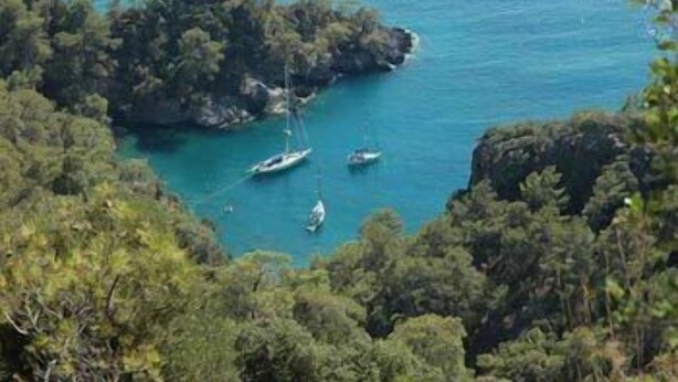 A coastal area with rocky terrain and clear blue waters. - Misafir Evi Hotel (Fethiye)