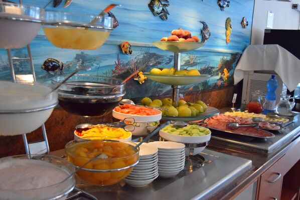 Un buffet proposant une variété de plats et un mur décoratif orné de poissons et de coraux.