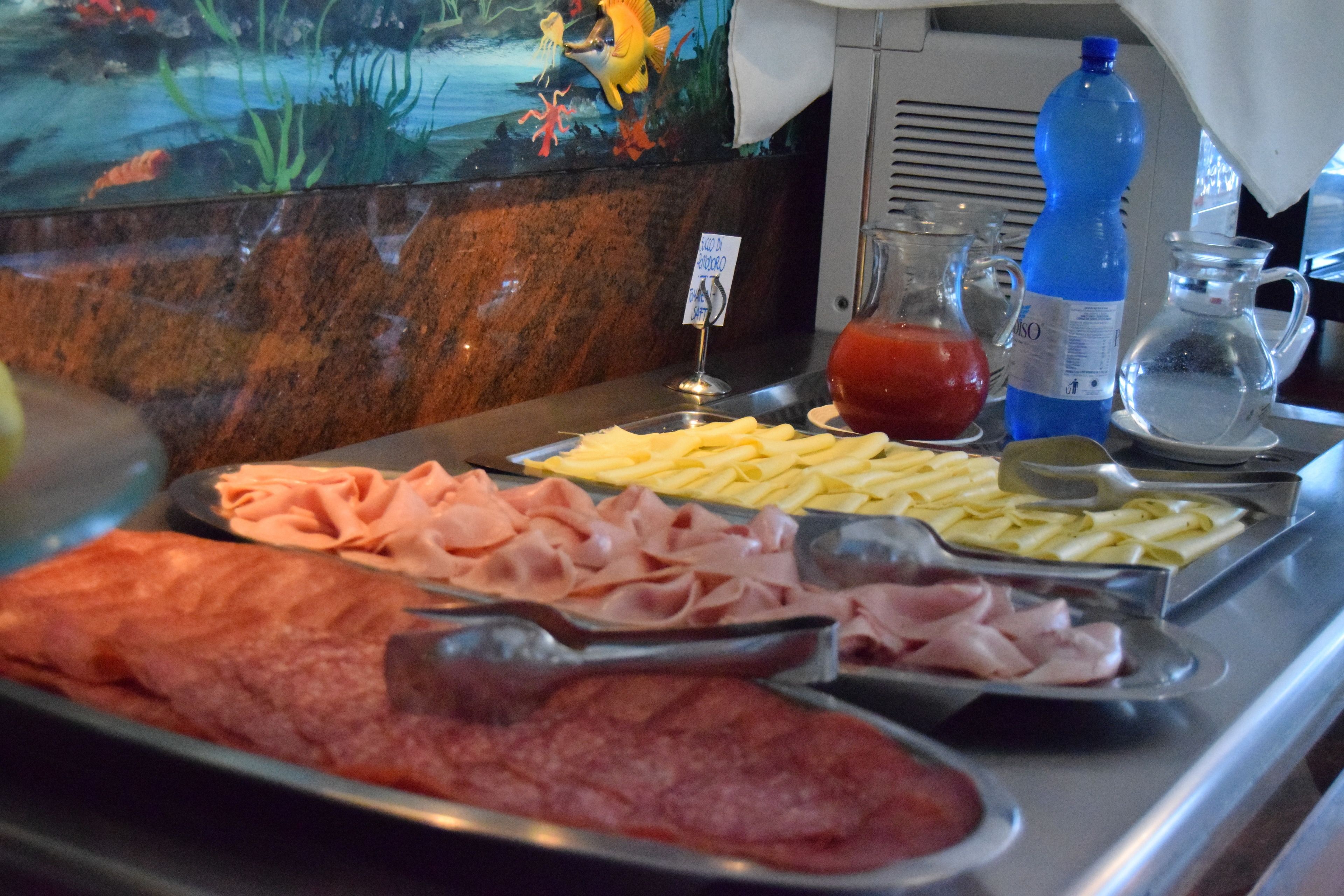 A buffet with various meats and cheeses.