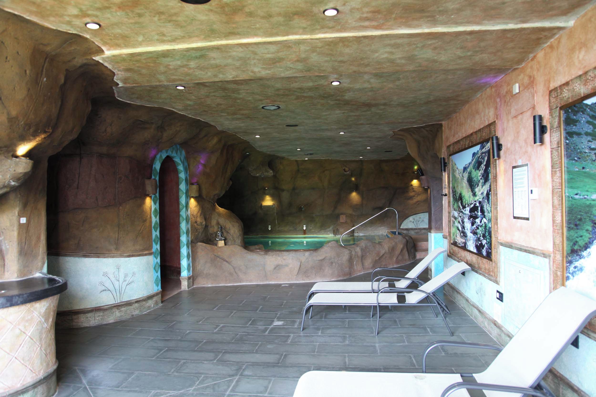 A spa area with a hot tub, seating, and a mural.