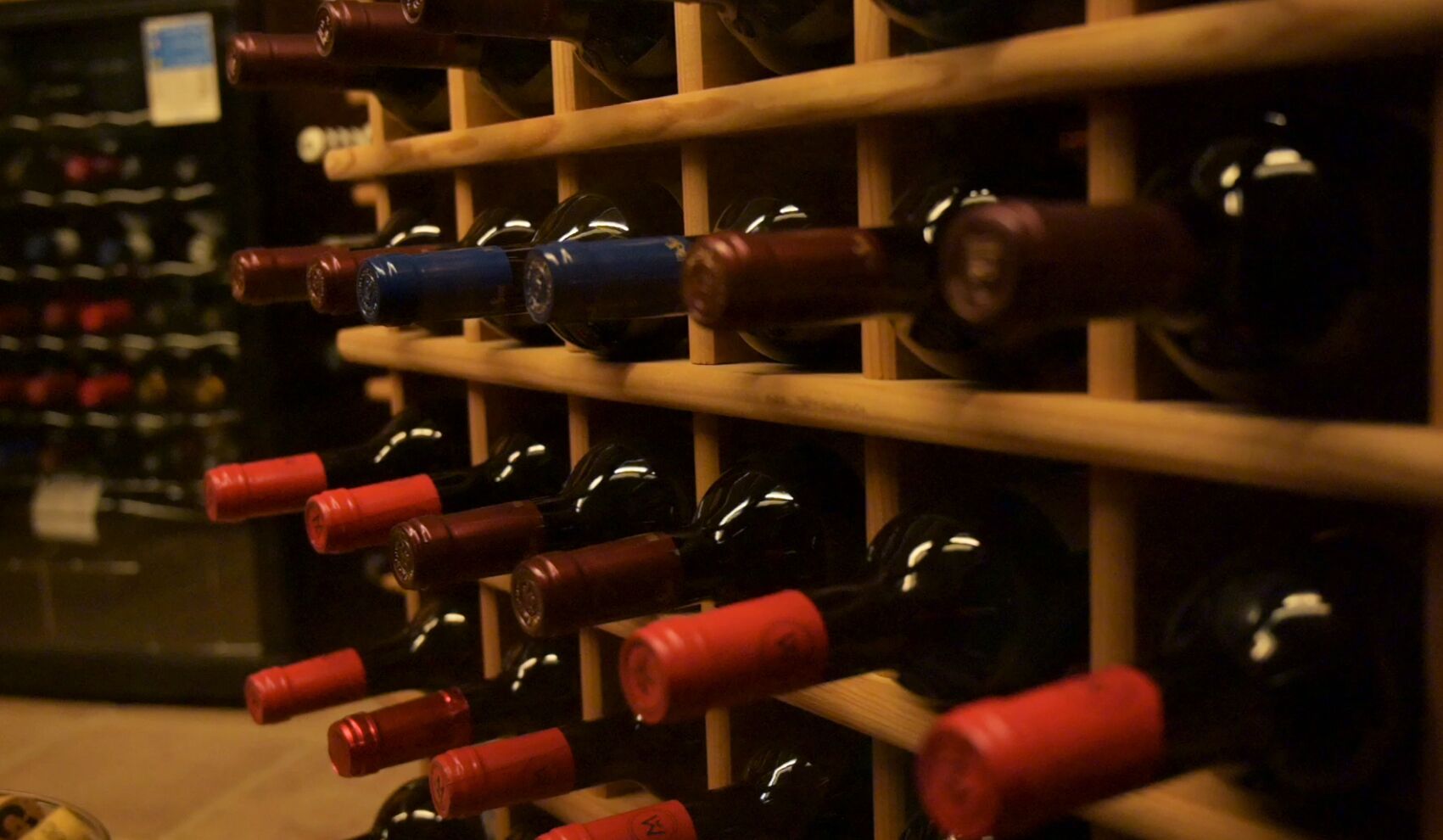 A wine rack with bottles in a dimly lit room.