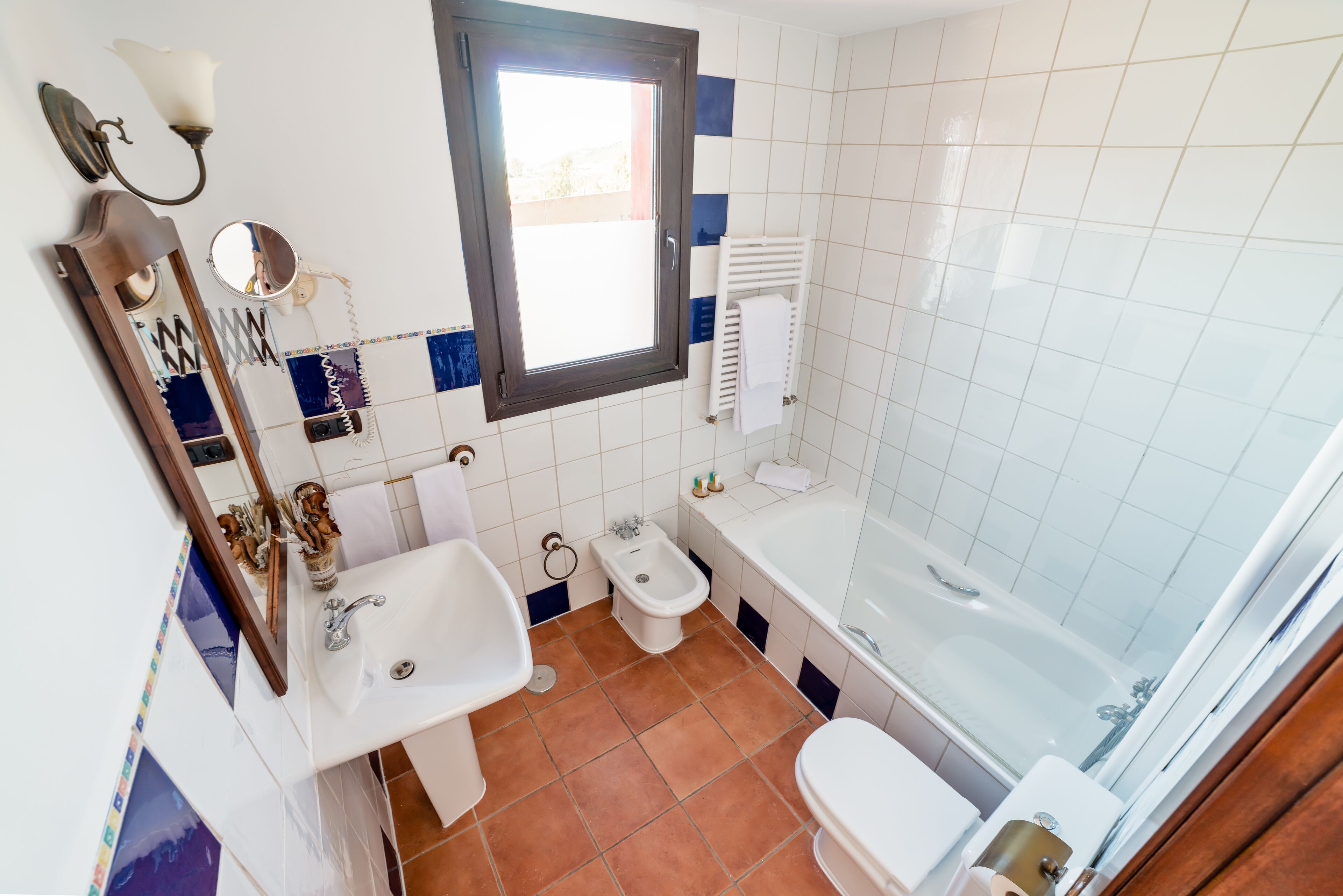 A bathroom with a sink, toilet, bidet, and bathtub.
