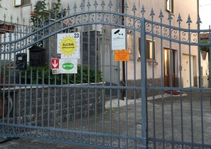 A gated entrance with a sign indicating a surveillance area and a request to close the gate for a child. - Elicrim (Santo Stefano di Magra)