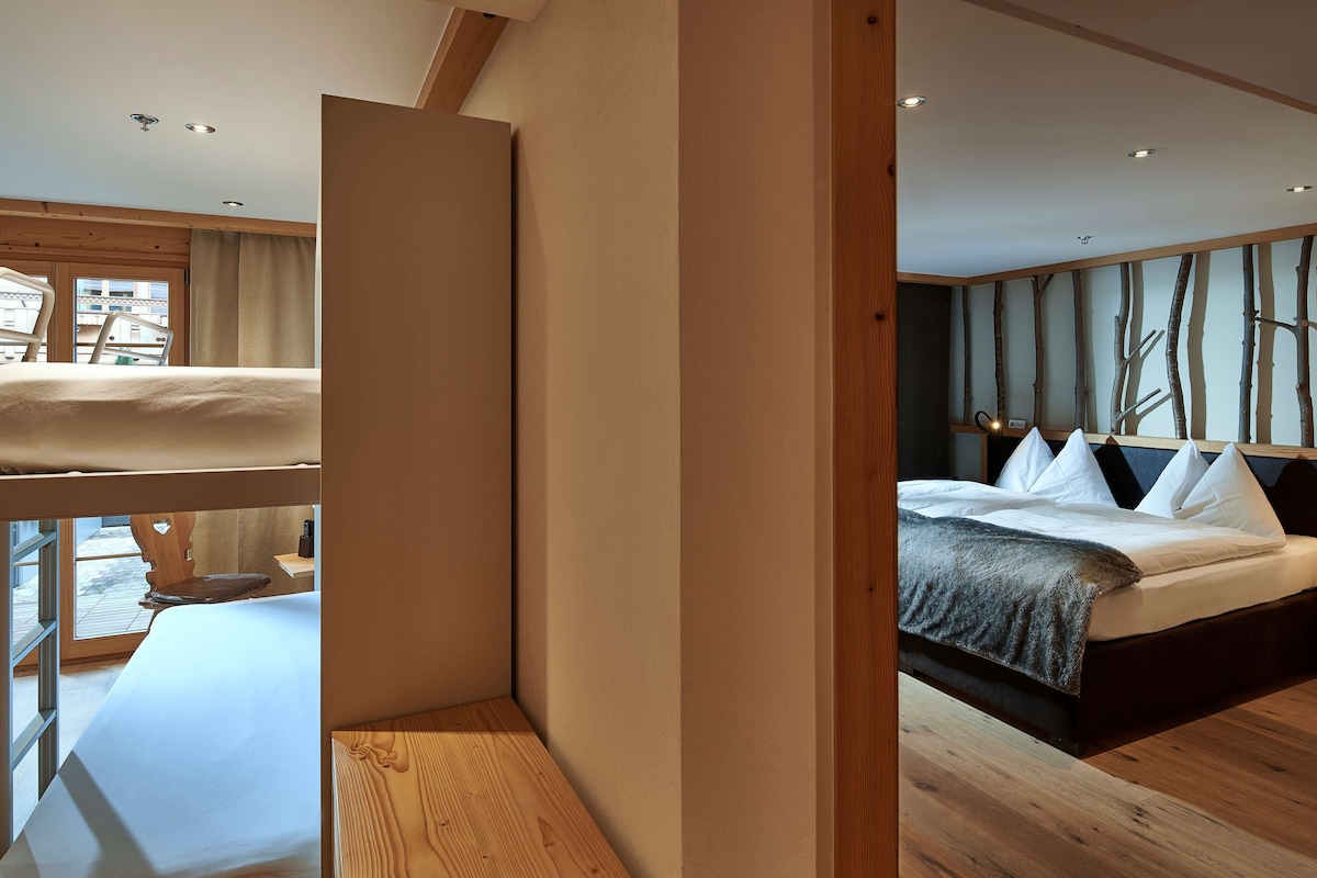 Un dormitorio moderno con una cama grande, un cabecero de madera y vistas al exterior.