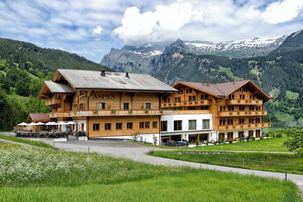 A large wooden building with multiple balconies and a restaurant area with outdoor seating.