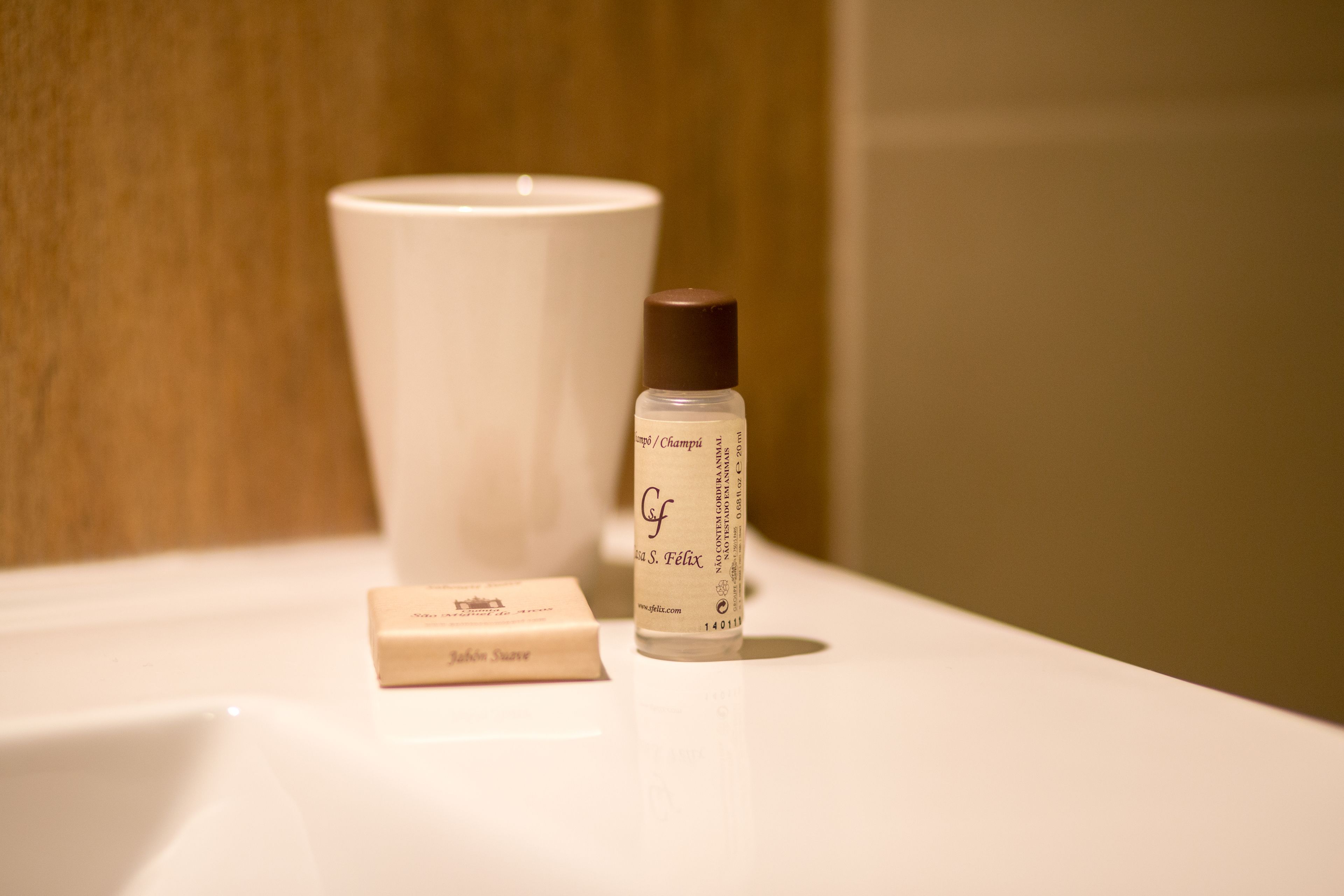 A bathroom sink with a bottle of shampoo and a bar of soap.