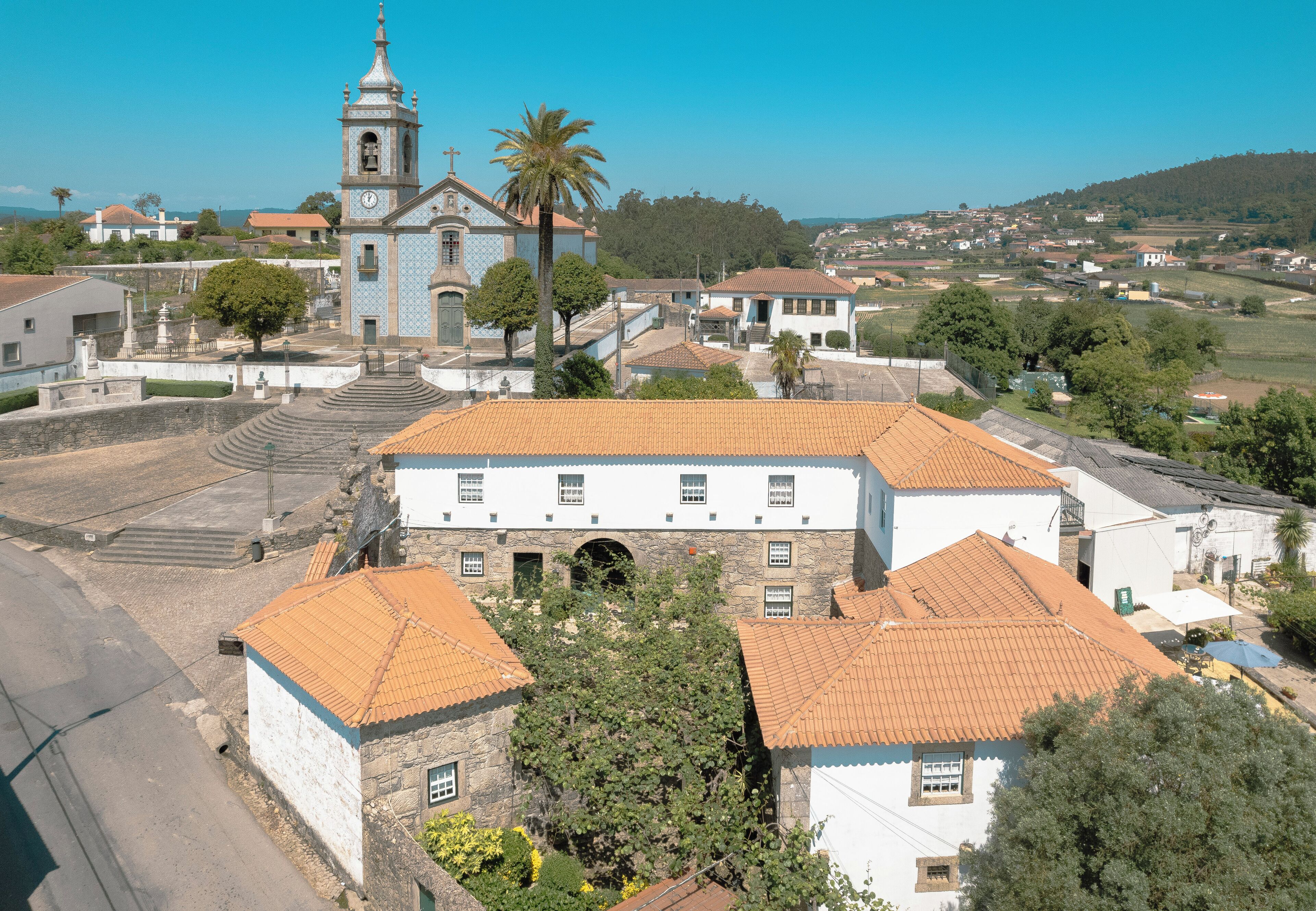 A historic building with a bell tower, surrounded by trees and other buildings.