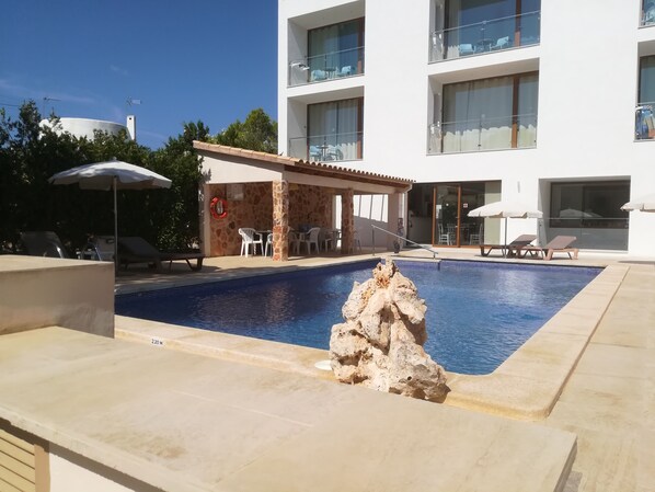 室外游泳池，開放時間為 10:00 至 19:00，提供泳池遮陽傘和日光浴躺椅