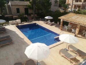 室外游泳池，開放時間為 10:00 至 19:00，提供泳池遮陽傘和日光浴躺椅