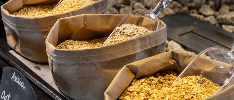 Three bags of oats labeled "Avena Oatmeal" on a wooden surface.