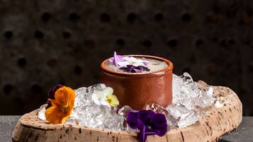Un postre sobre una tabla de madera, con hielo y flores.