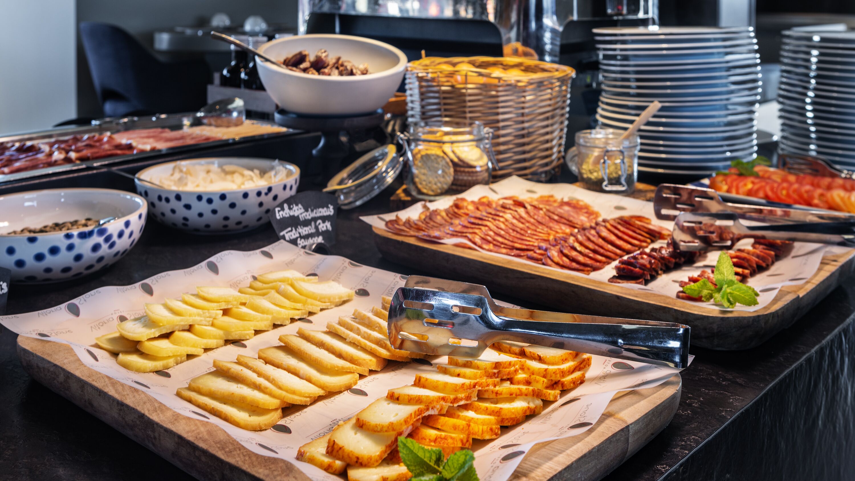 A buffet with various food items including bread, pastries, and meats.