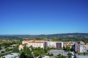 A high-rise residential building complex with multiple floors, surrounded by greenery and a clear blue sky. - Santa Eufémia Covilhã Hotel (Covilhã)
