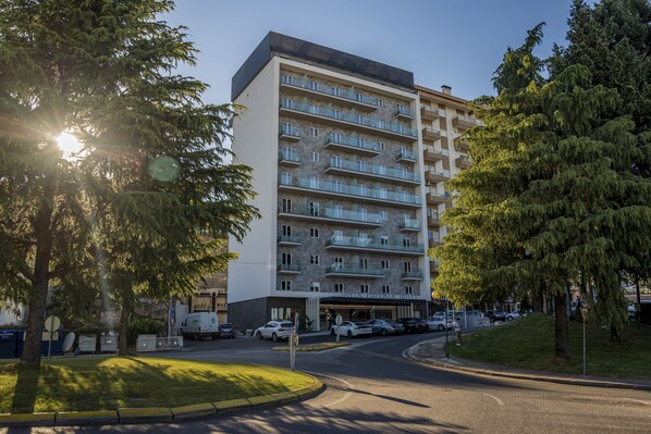 A multi-story hotel with balconies, a parking area, and a street view. - Santa Eufémia Covilhã Hotel (Covilhã)