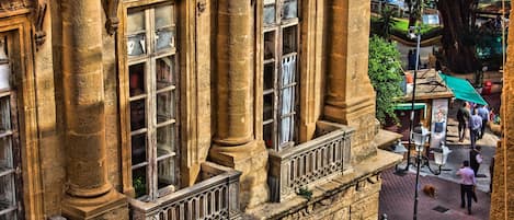 A historic building with ornate stonework, large windows, and a balcony.