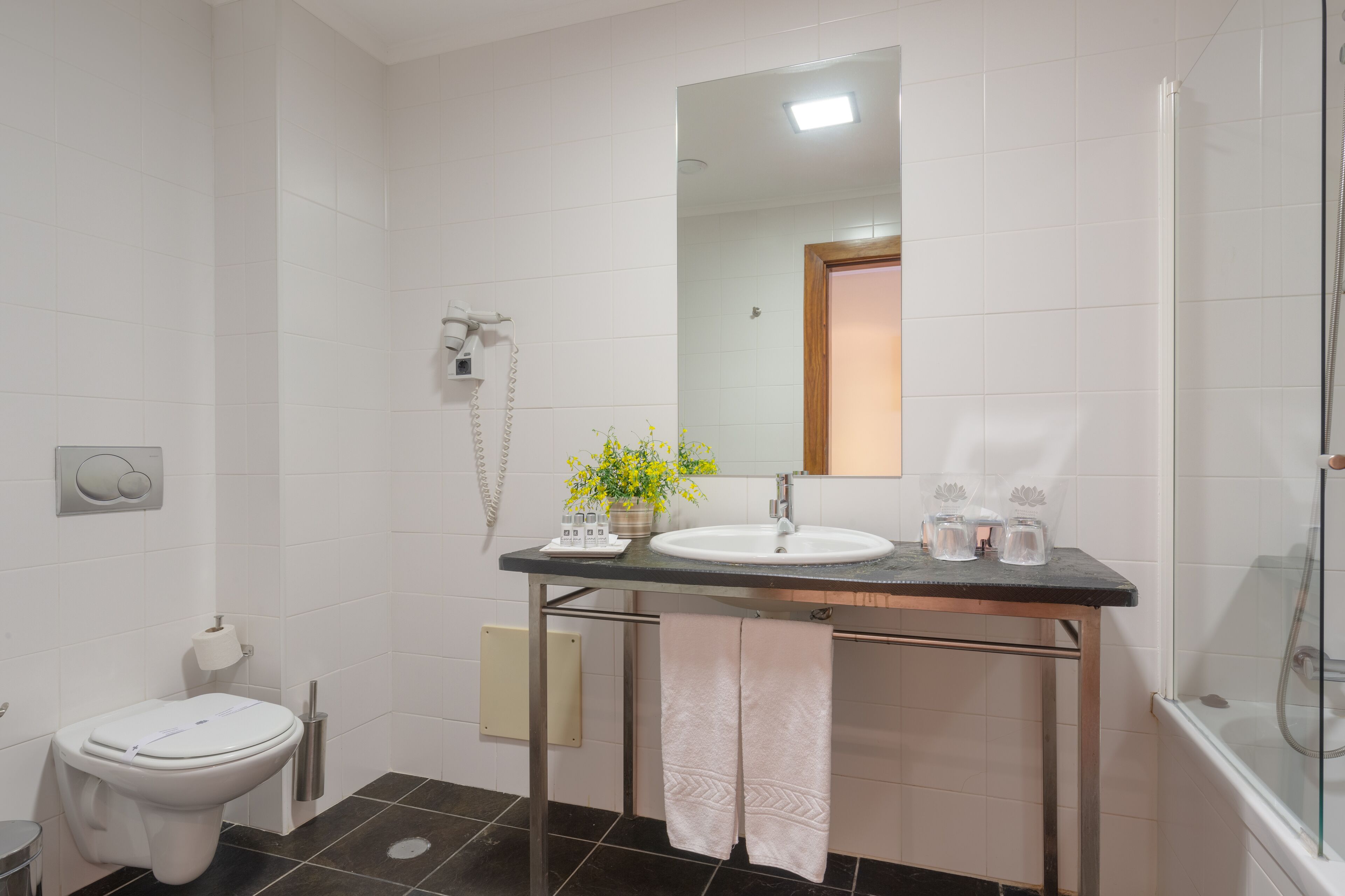 A modern bathroom with a toilet, sink, and shower.