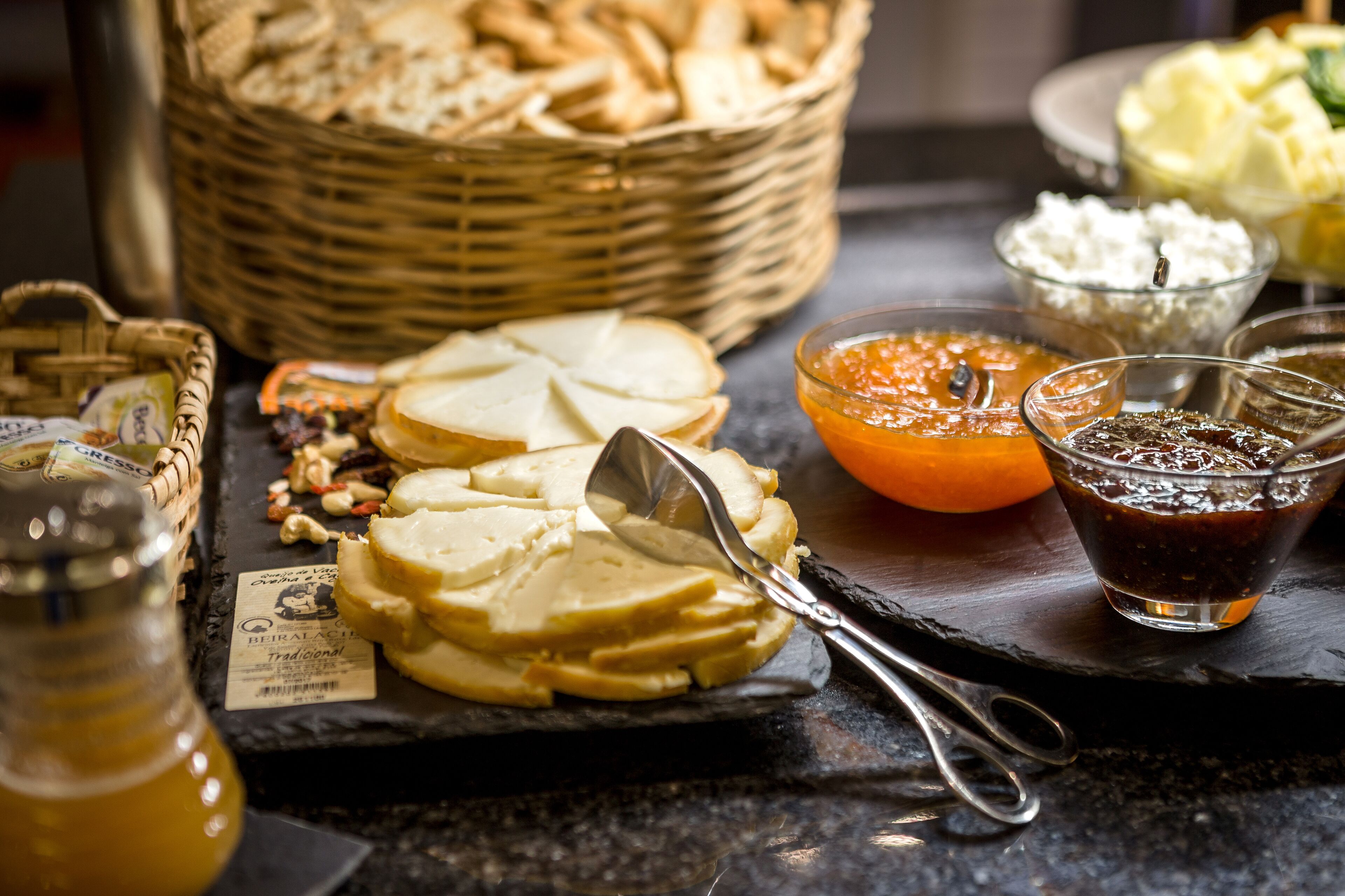 Una tabla de queso con distintos tipos de queso, frutos secos y mermeladas.