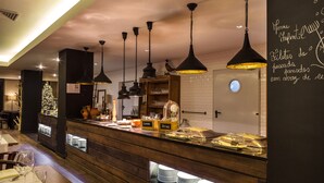 A buffet area with a wooden counter, hanging pendant lights, and a chalkboard menu. - Puralã - Wool Valley Hotel & SPA (Covilhã)