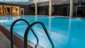 An indoor swimming pool with clear water, surrounded by columns and a tiled floor. - Puralã - Wool Valley Hotel & SPA (Covilhã)
