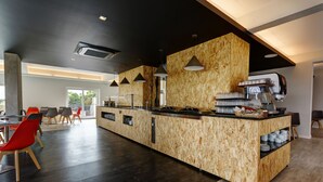 A modern kitchen with a central island, built-in appliances, and pendant lighting. - Sport Hotel Gym + SPA (Covilhã)