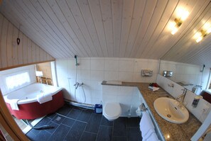 A bathroom with a bathtub, toilet, sink, and a shower. - Chalet Hotel Adler (Kandersteg)