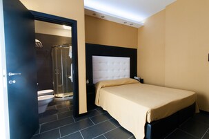 Une chambre d’hôtel avec un lit, une douche et des toilettes.