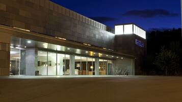 Experience the sleek, contemporary design of this hotel, featuring a prominent entrance and glass facade.