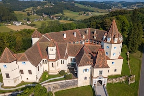 A large, historic building with multiple towers and a central courtyard.