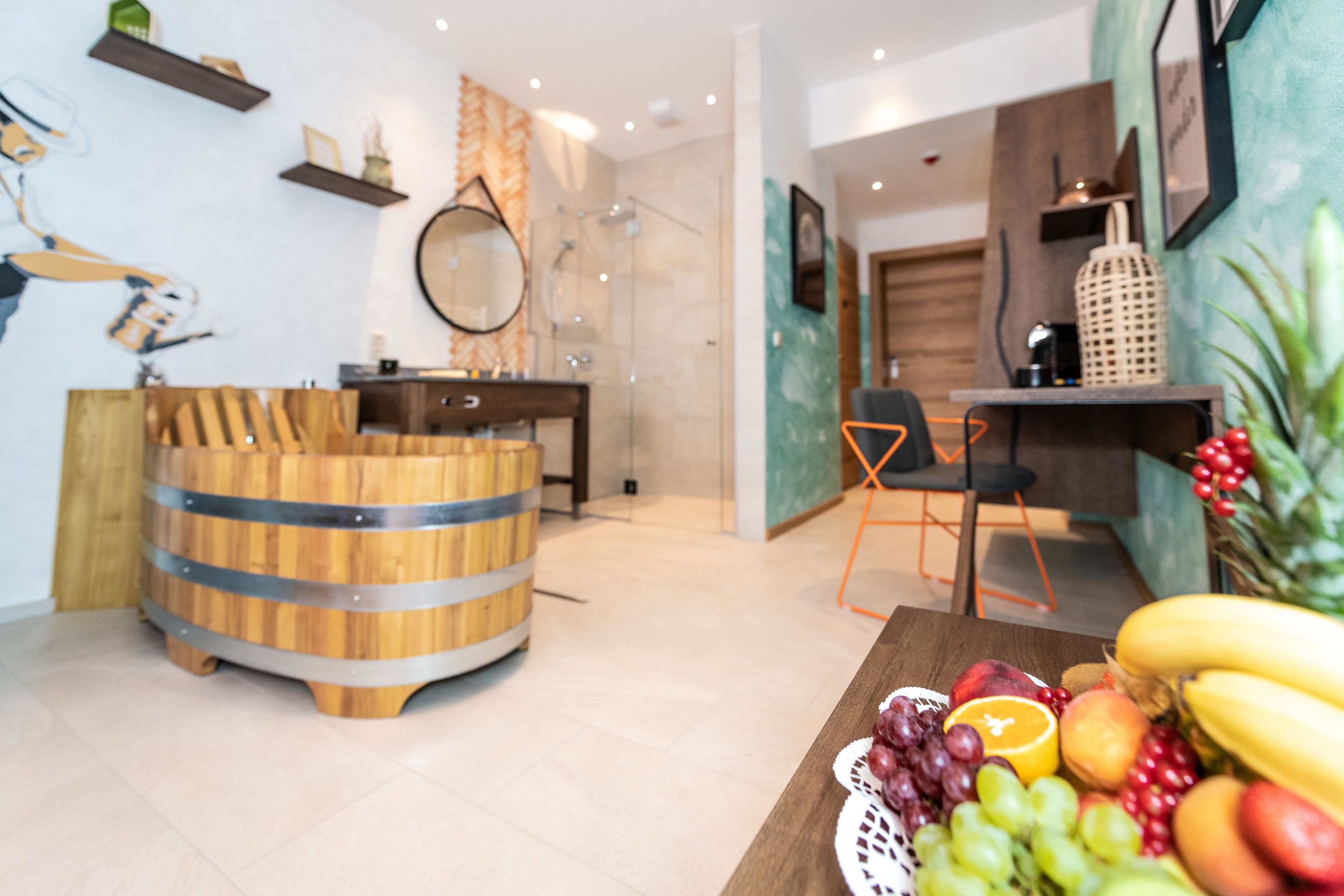 Una cocina moderna con un barril de madera, una cesta de frutas y una zona de comedor con una silla y una mesa.